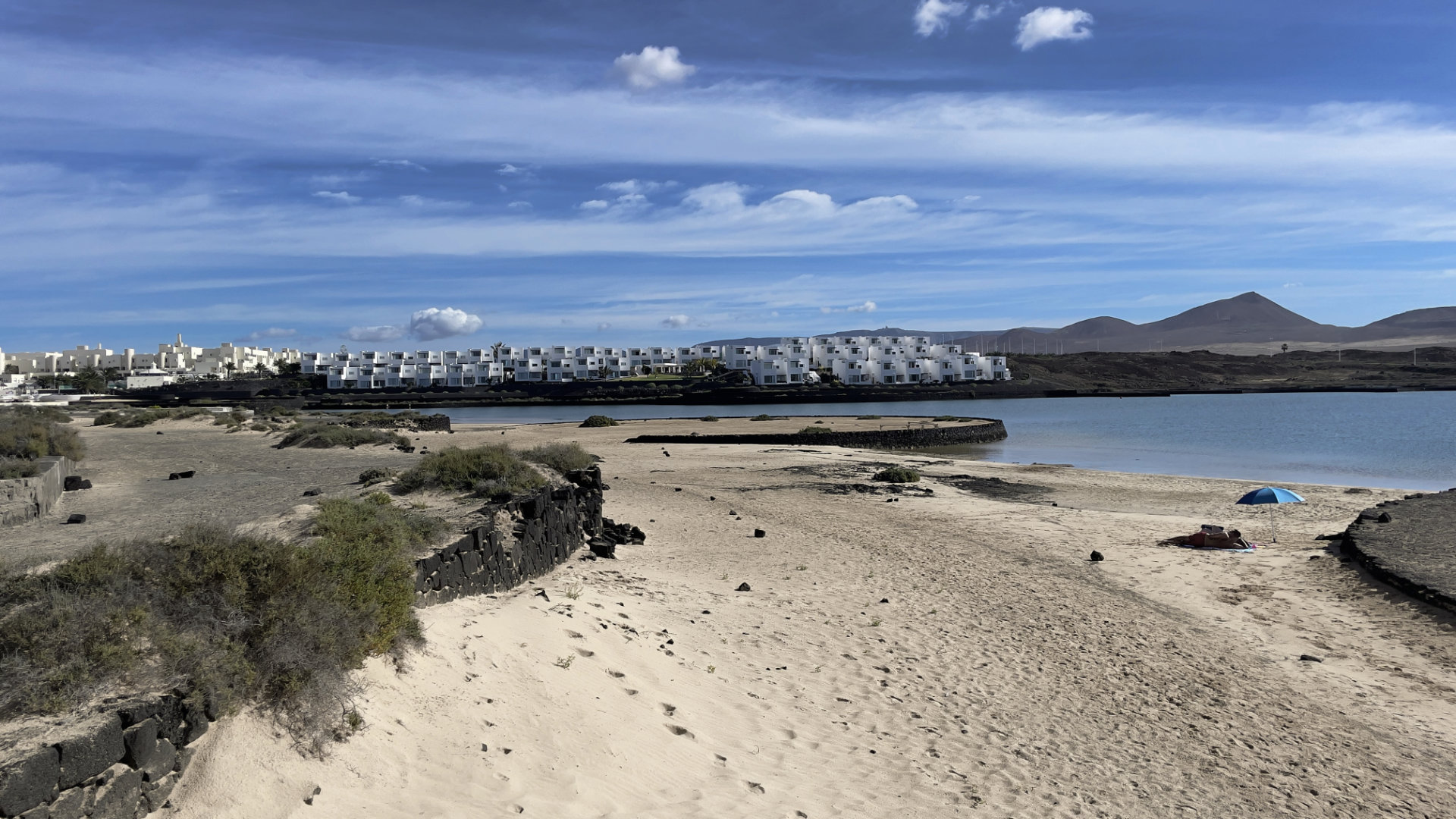Lagune mit Sandstrand mit Club La Santa speziell für Singlereisen auf Lanzarote im Hintergrund